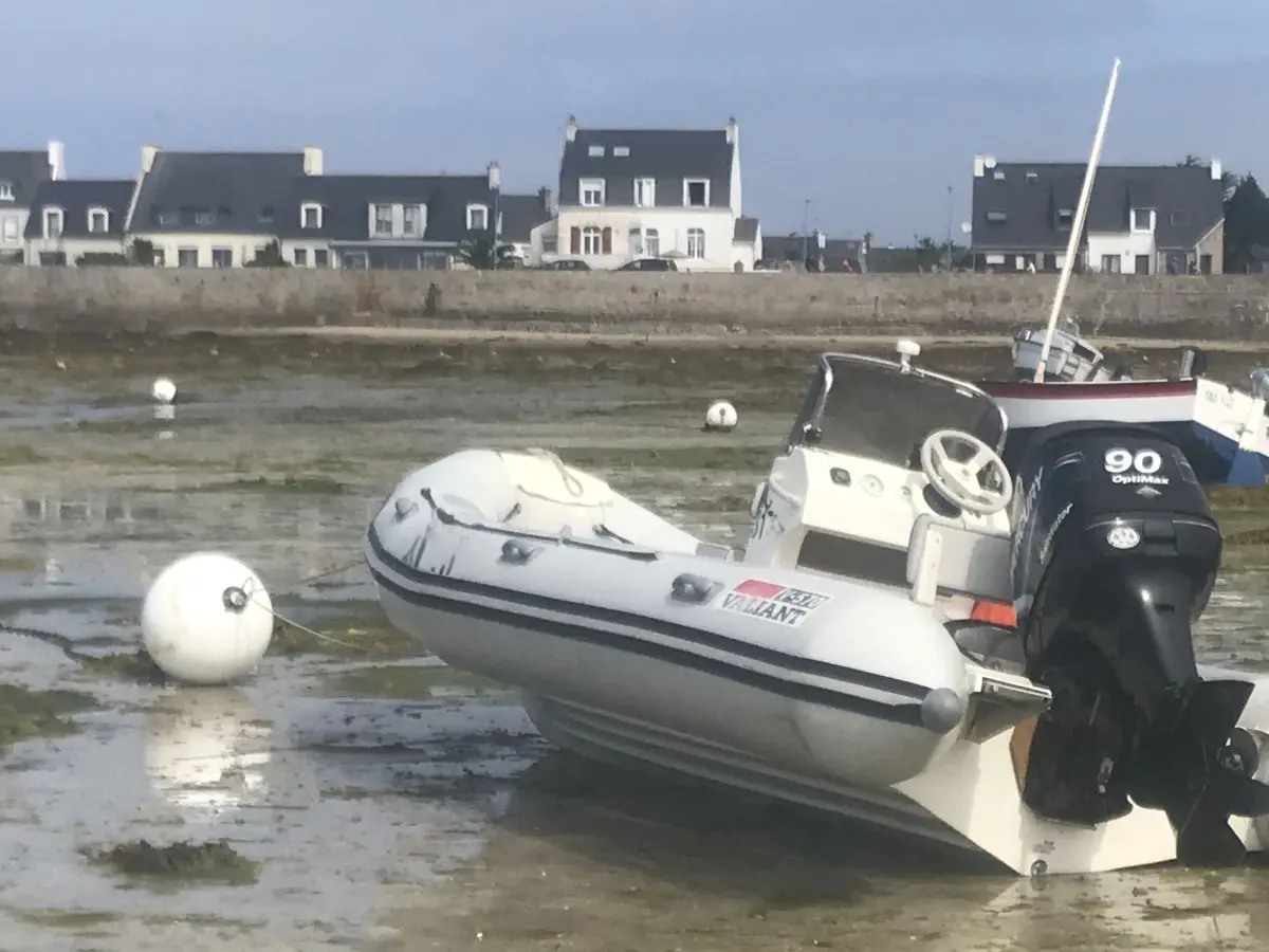 Valiant DR 570 — Bateau pneumatique à moteur hors-bord échoué sur l’estran à marée basse.
