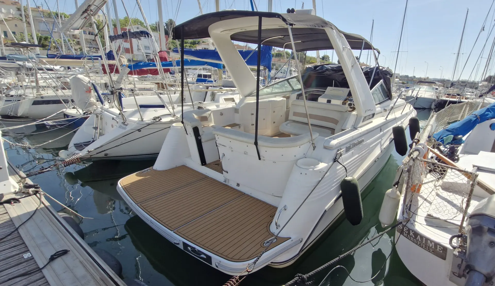 Cruisers Yachts 3070 Rogue — Bateau de plaisance blanc vu de trois quarts arrière dans une marina.