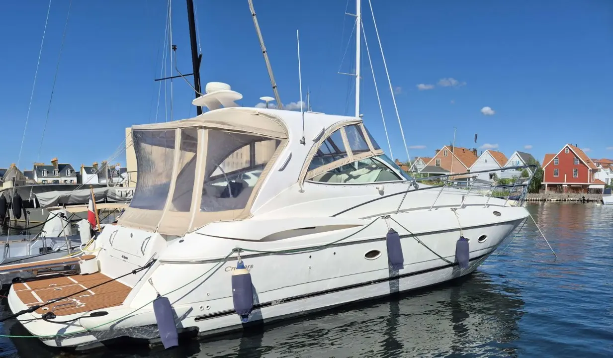 Cruisers Yachts 440 Express — Bateau à moteur blanc amarré dans un port, vu de trois quarts tribord.