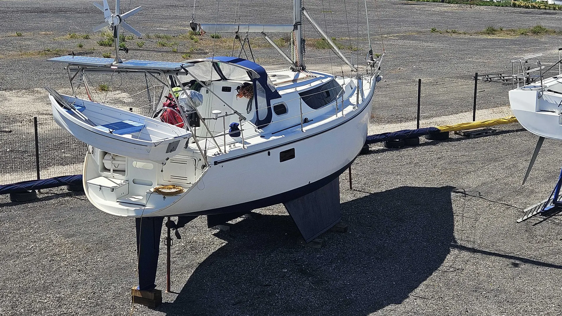 Wrighton Biloup 36 — Voilier blanc photographié à terre, vu de trois quarts arrière sur un chantier naval.