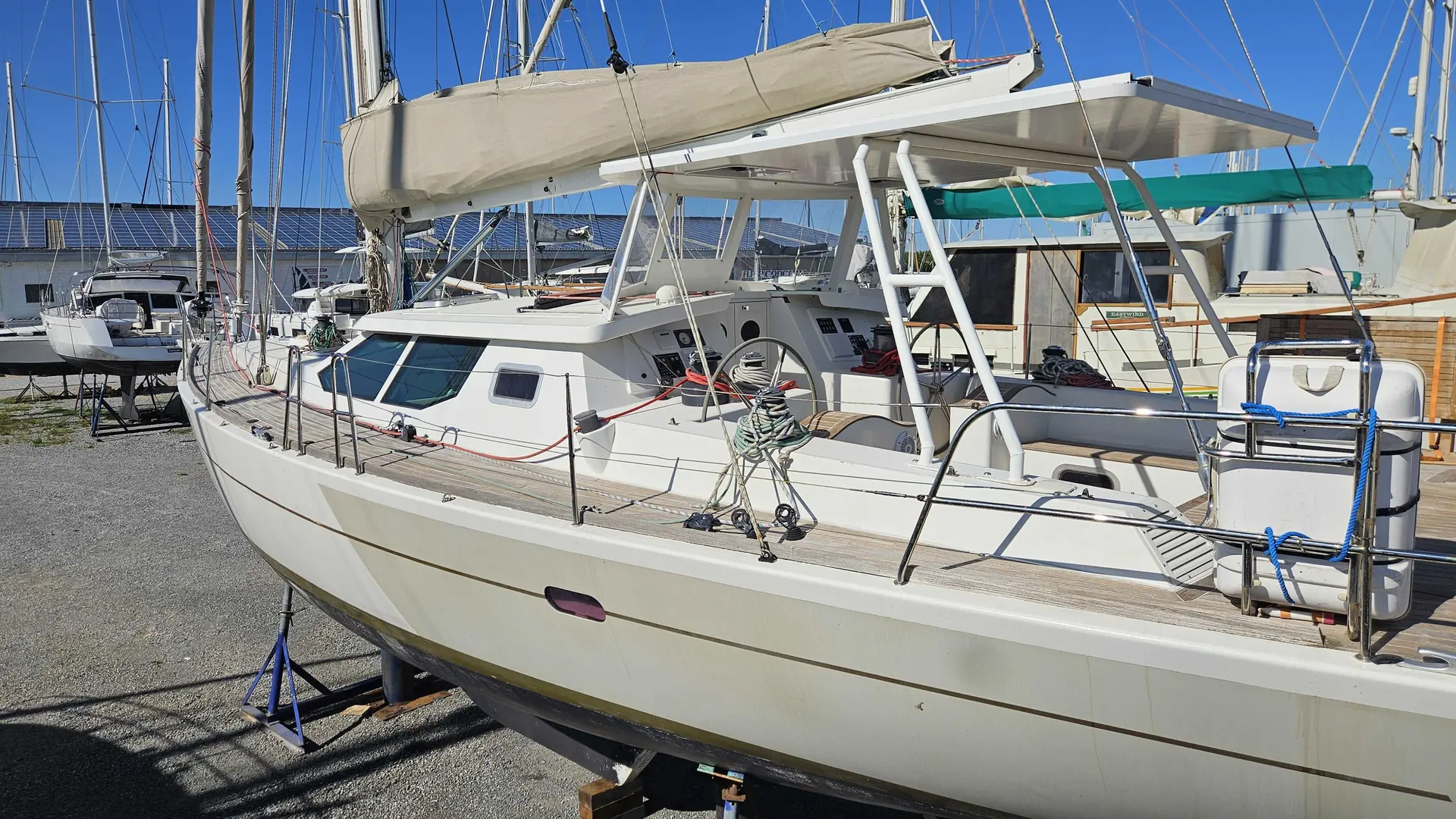 JFA 53 DS — Voilier blanc à cabine et grand cockpit, photographié à terre dans un chantier naval.
