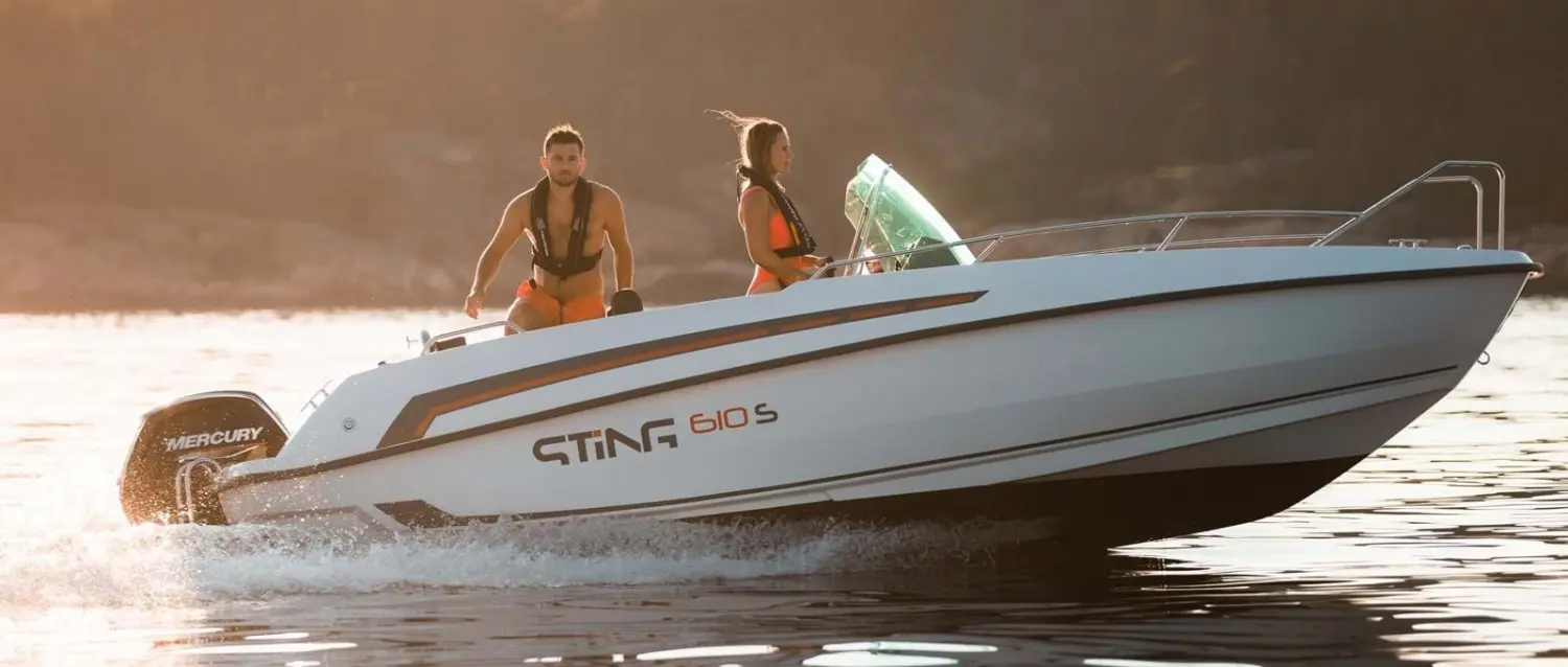 Sting 610 S — Vue latérale d’un bateau Sting 610 S naviguant avec deux personnes à bord.
