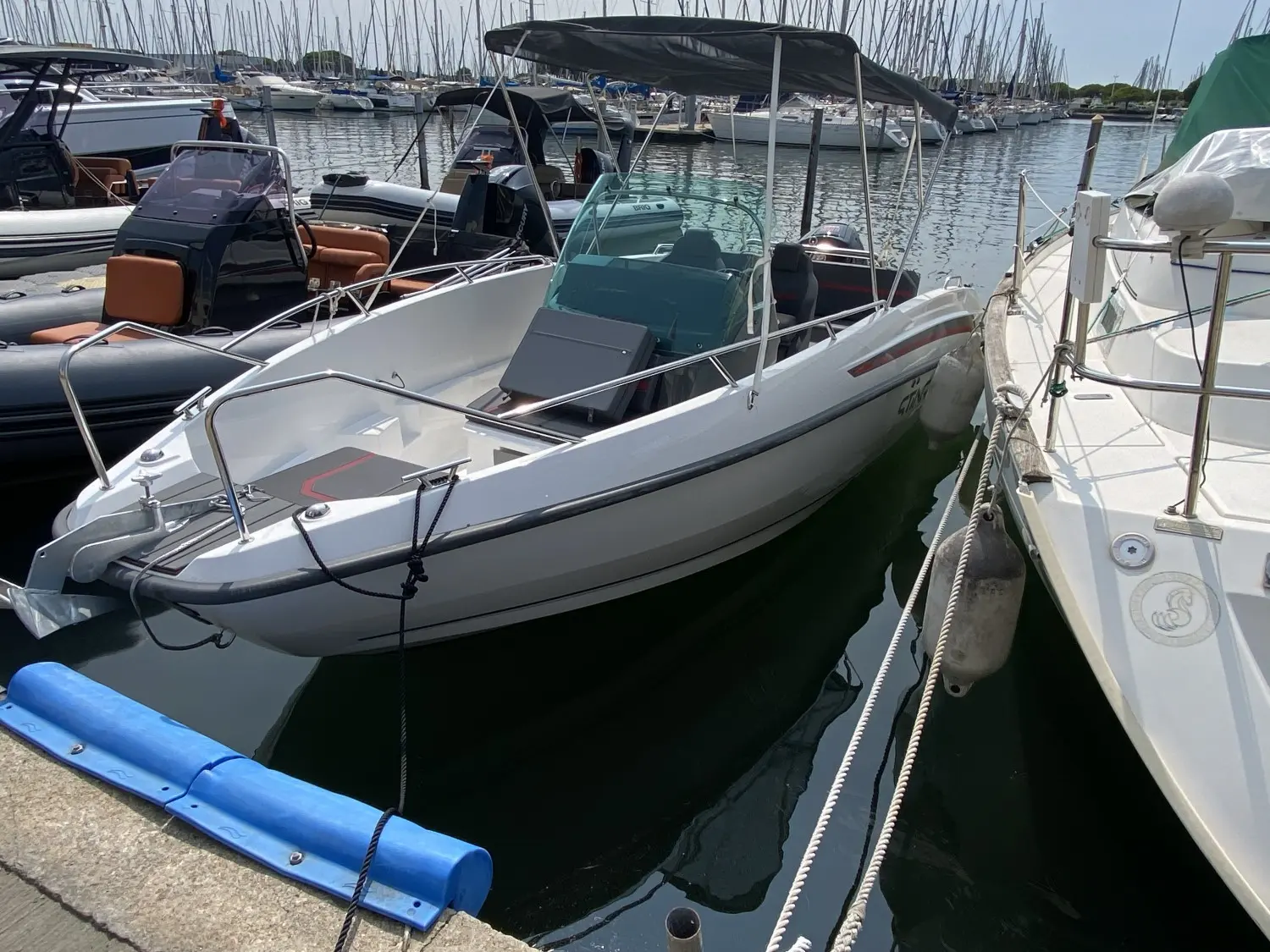 Sting 610 S — Bateau à moteur blanc amarré dans un port de plaisance.