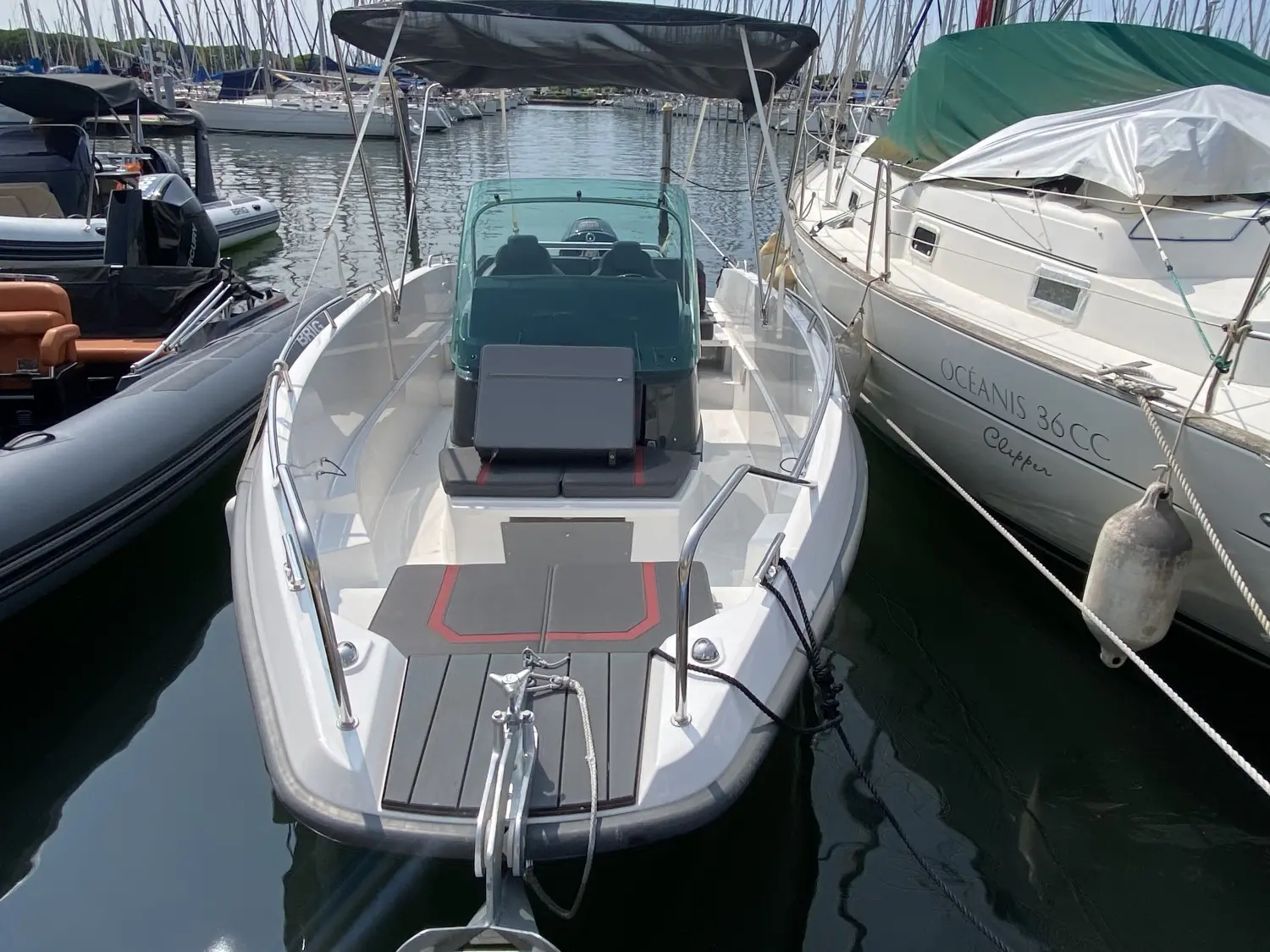 Sting 610 S — Bateau à moteur blanc amarré dans une marina, vu de l’avant.