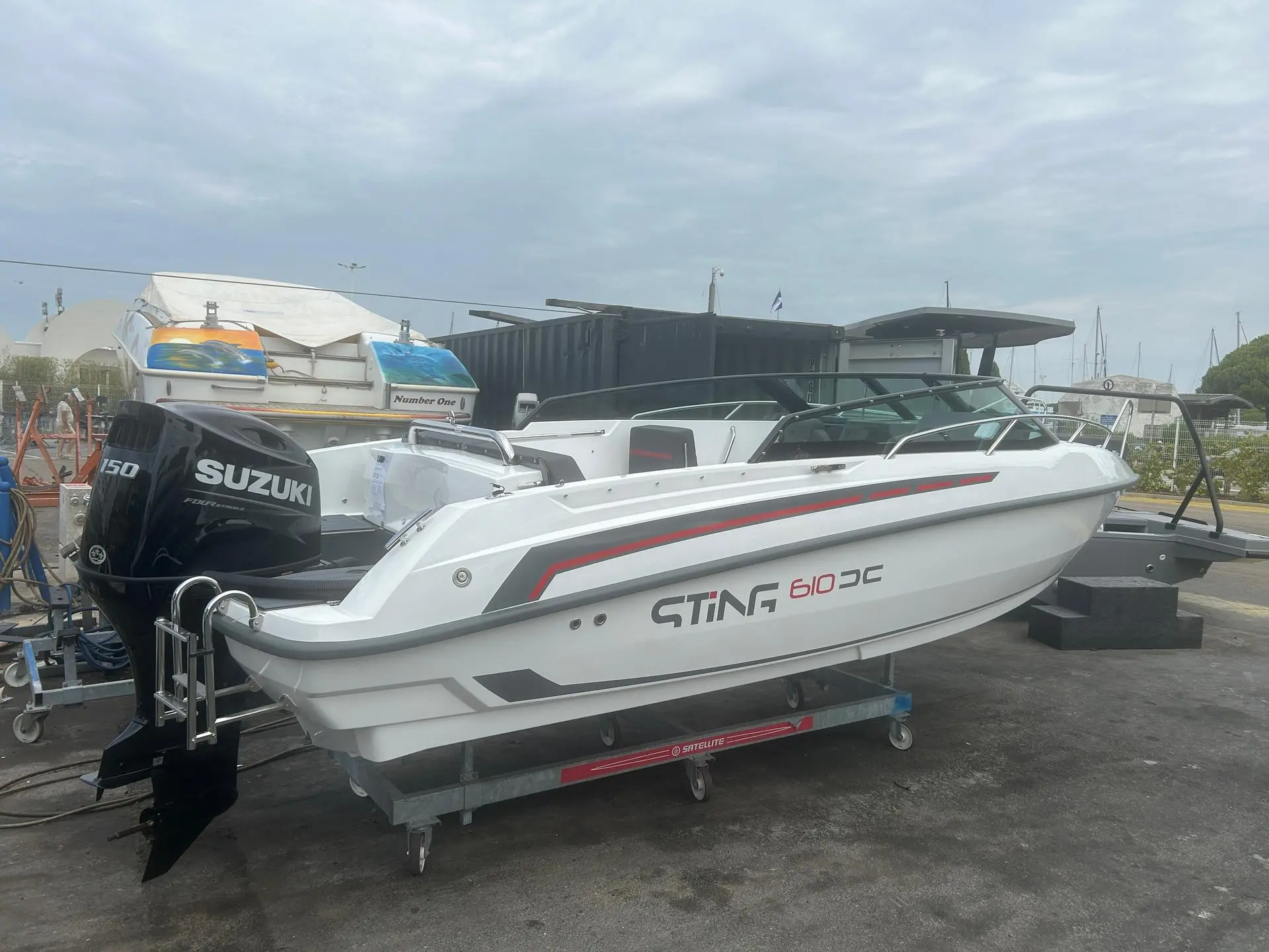 Sting 610 DC — Bateau blanc à moteur hors-bord, photographié sur sa remorque.