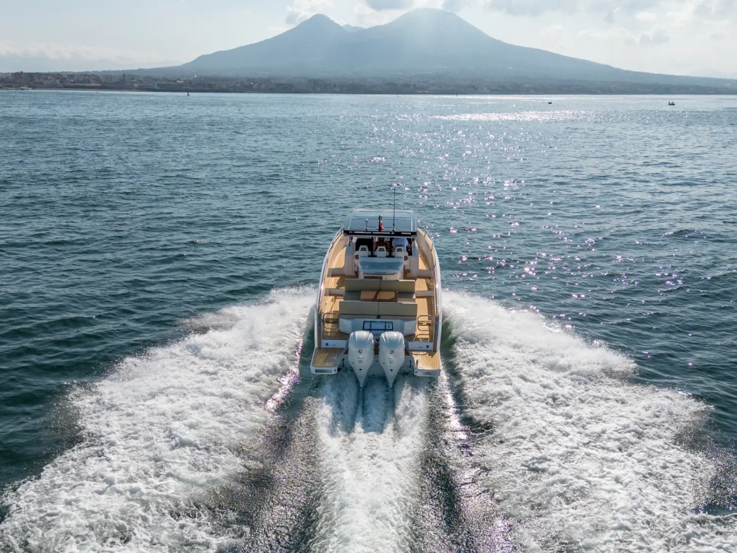 Salpa Avantegarde 35 — Bateau à moteur vu de l’arrière, naviguant sur une mer calme devant des montagnes.