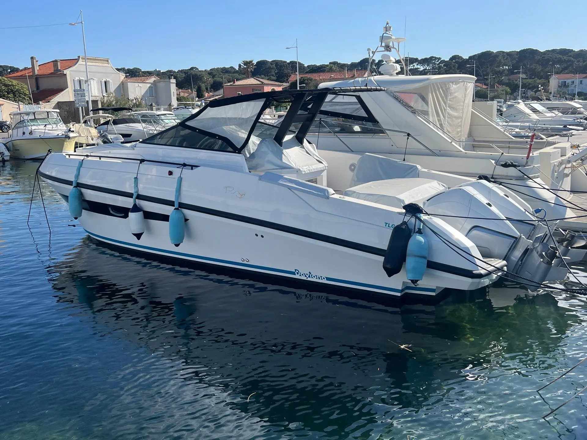Rio Yachts Daytona 34 — Bateau à moteur blanc amarré dans un port, vu de trois quarts.