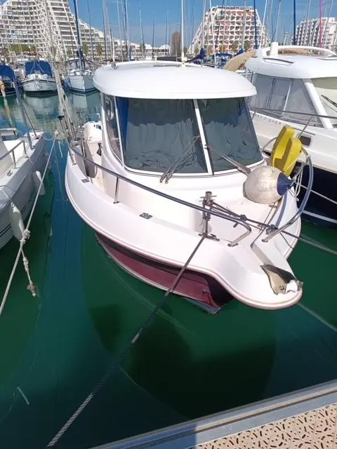 Arvor 230 — Bateau à moteur blanc amarré dans une marina, vu de trois quarts avant.