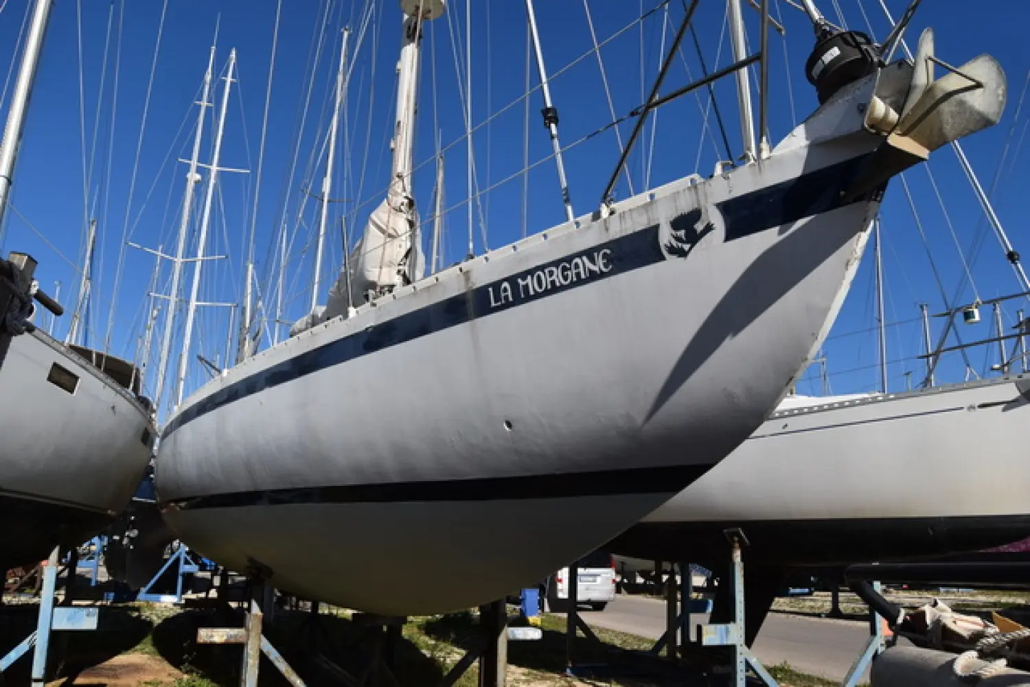 Pouvreau Meridien — Voilier blanc nommé LA MORGANE, photographié à terre entre d’autres bateaux.