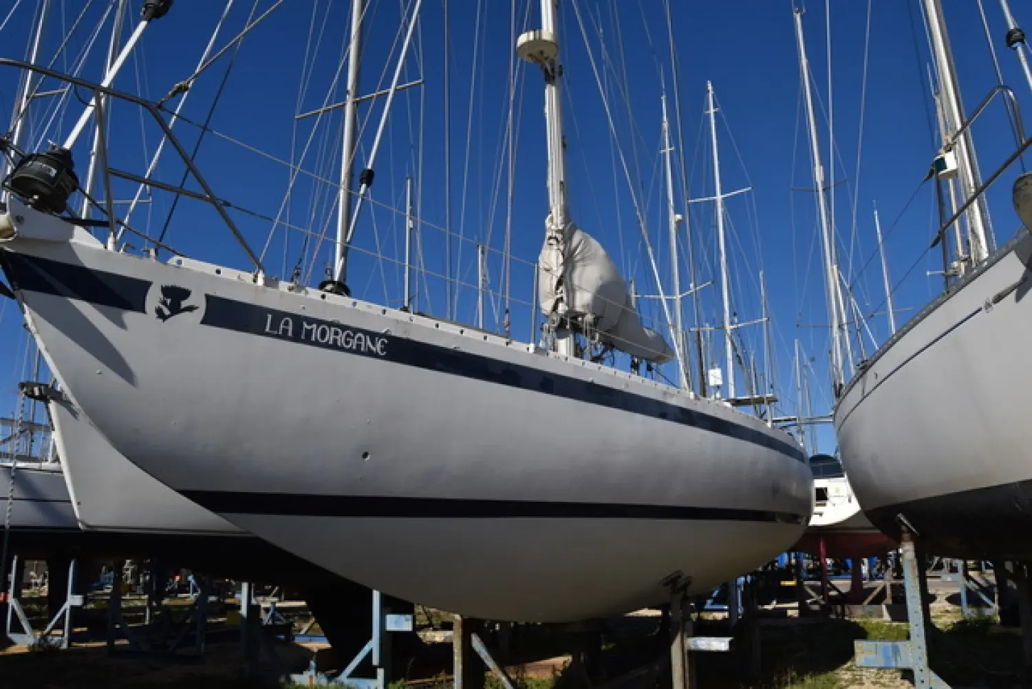 Pouvreau Meridien — Voilier blanc à l’eau lors d’un hivernage à terre, entouré d’autres bateaux.
