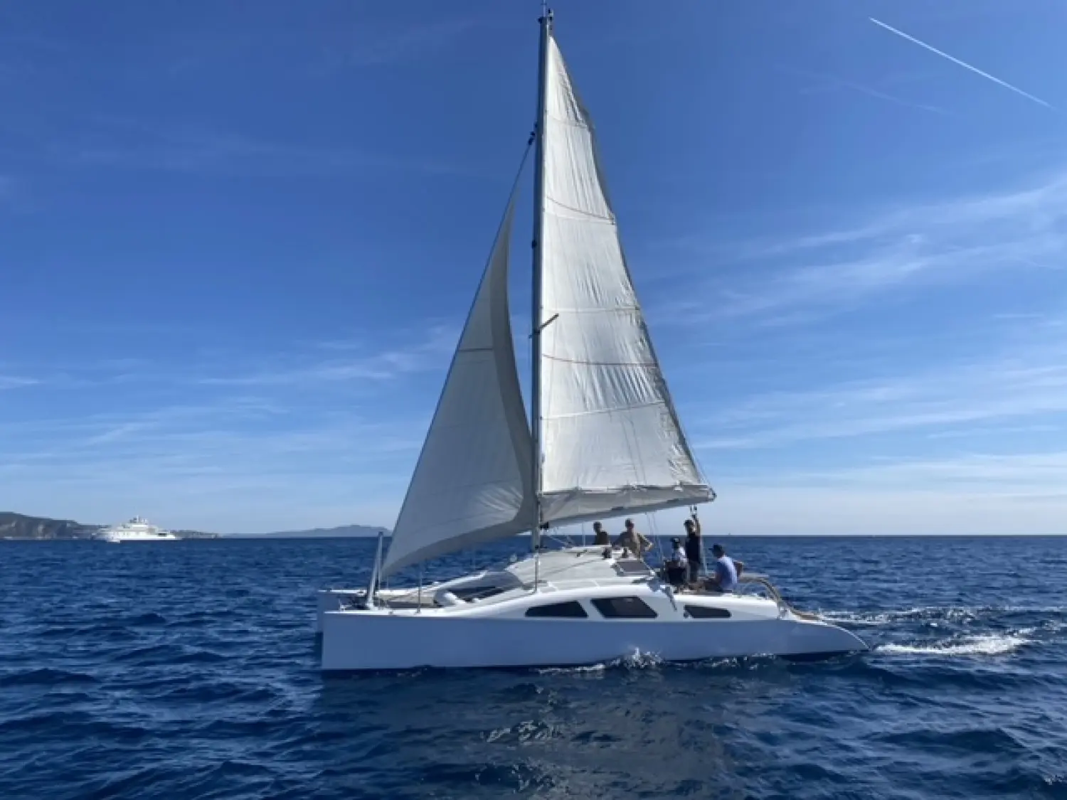 Labbe Cite D'aleth Ii — Voilier blanc naviguant sous voiles en mer, avec plusieurs personnes à bord.
