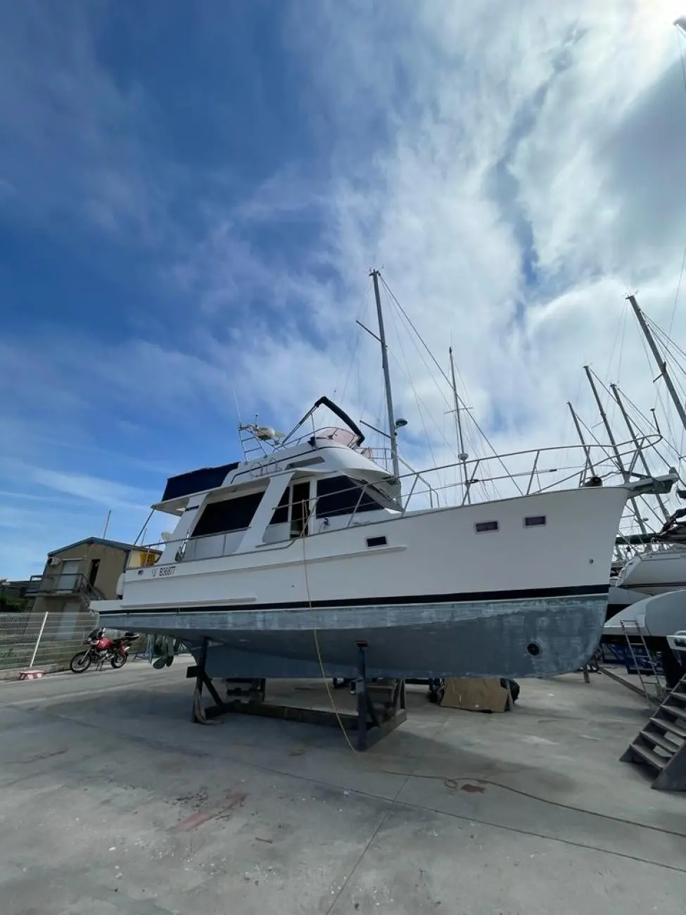 Nautica 36 Europa — Bateau à moteur blanc photographié à terre dans une zone de maintenance nautique.