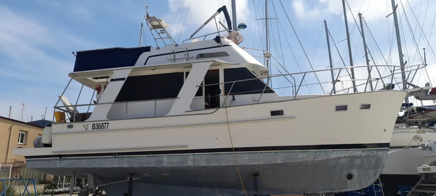 Nautica 36 Europa — Bateau à moteur blanc photographié à terre dans un port, vu de profil.