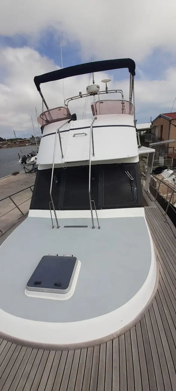 Nautica 36 Europa — Vue avant d’un bateau à moteur amarré, avec pont avant et poste de pilotage.