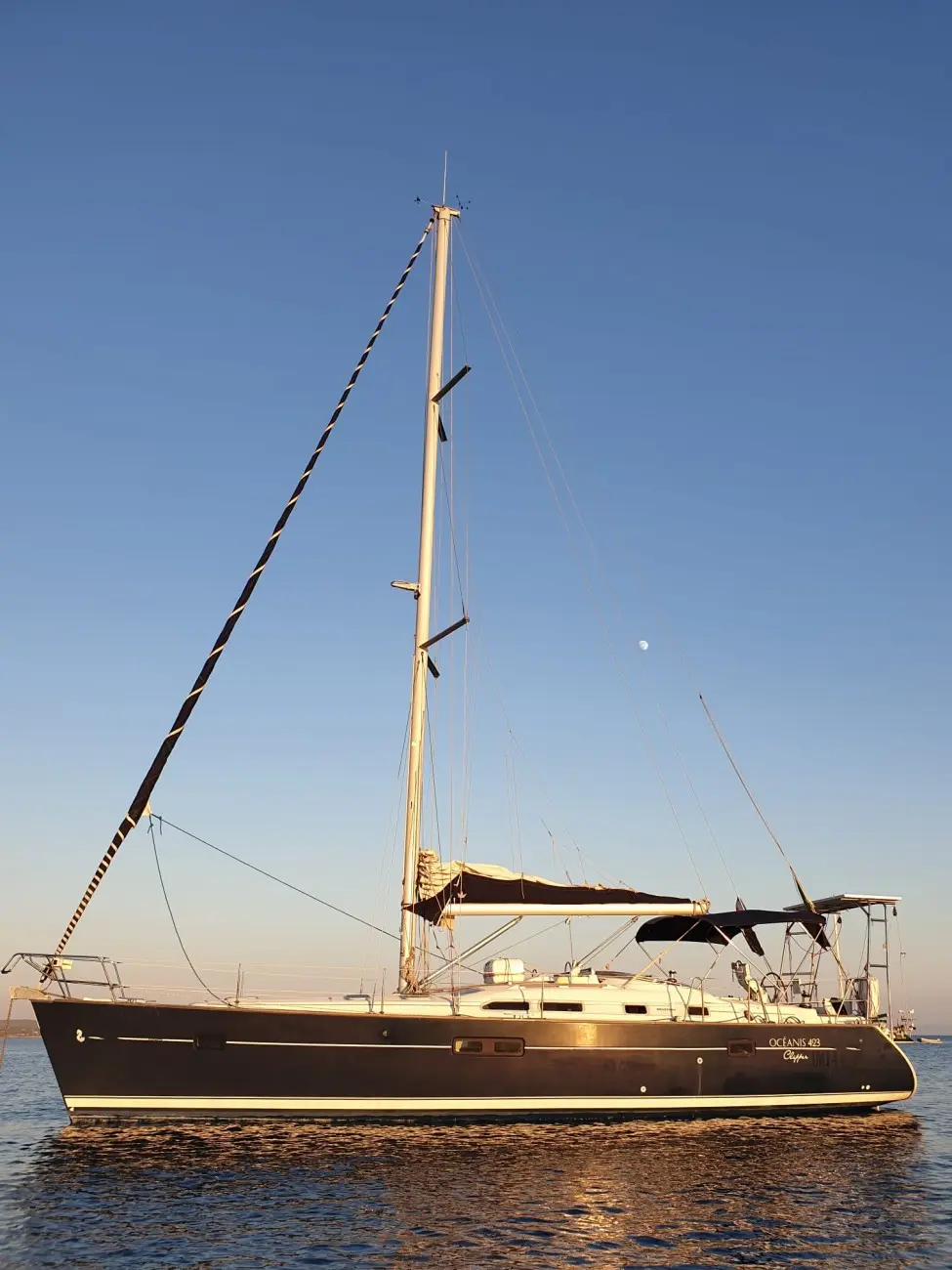 Beneteau Oceanis 423 — Voilier monocoque vu de profil sur l’eau, avec mât, gréement et taud de cockpit.
