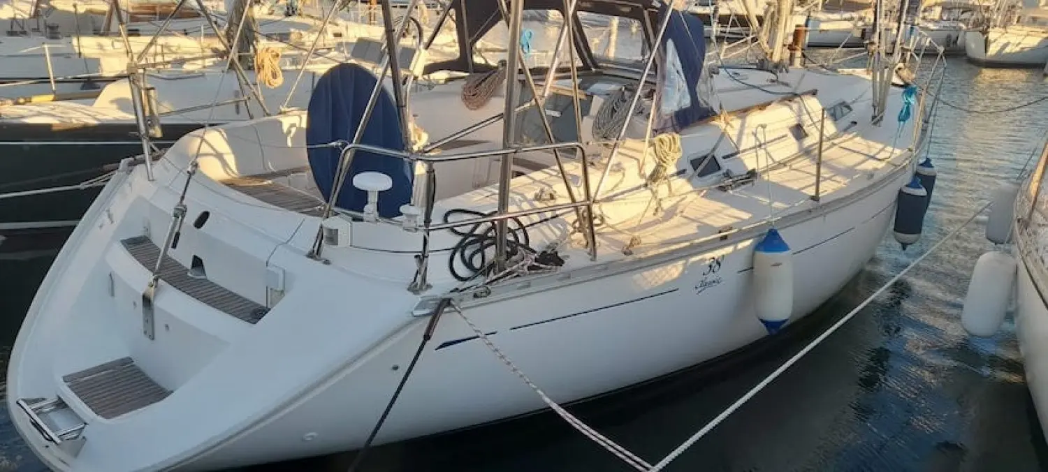 Dufour 38 — Voilier blanc amarré dans une marina, vu de trois quarts arrière.