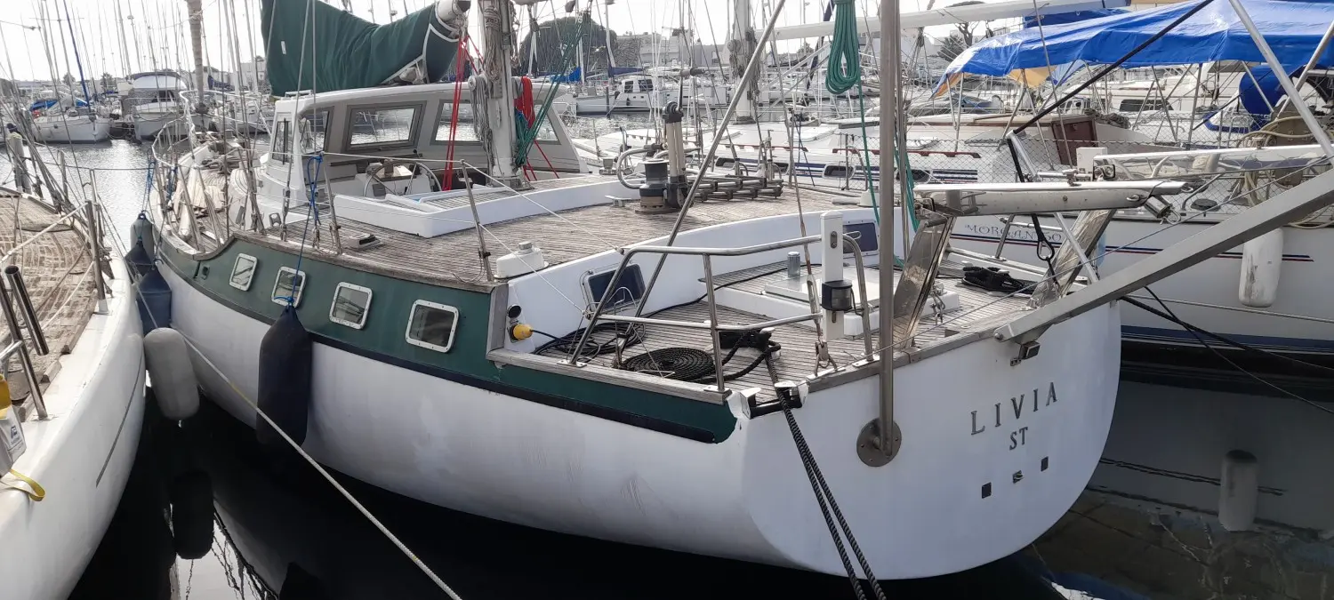 CNSO Mikado — Voilier blanc et vert amarré dans un port, vu de trois quarts arrière.
