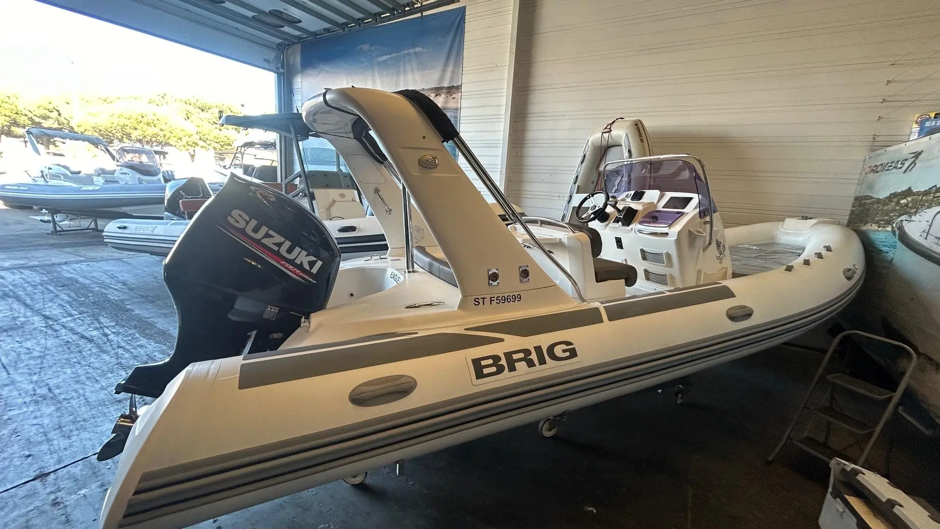 Brig Eagle 650 H — Bateau pneumatique semi-rigide Brig photographié en intérieur avec moteur hors-bord.