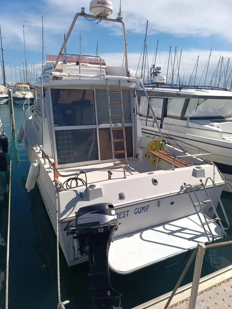 Artaban 800 — Bateau vu de poupe dans une marina, avec annexe hors-bord et passerelle arrière.