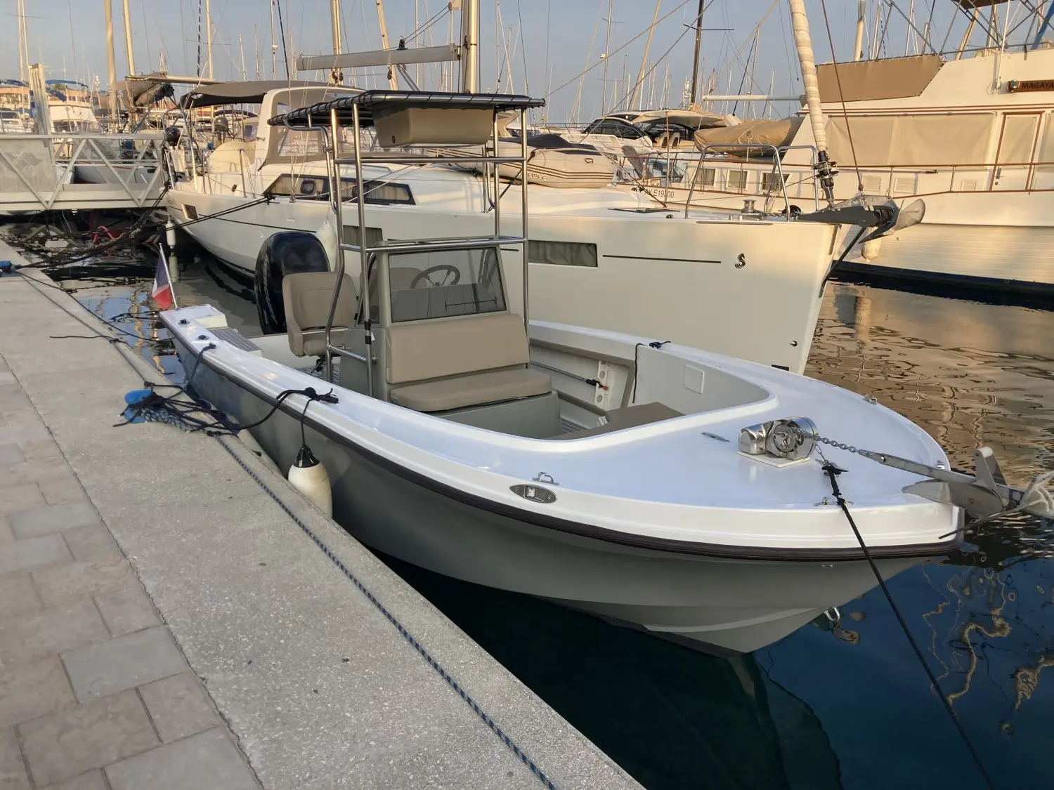 Mako 211 — Bateau à moteur blanc amarré dans une marina, vu de trois quarts avant.