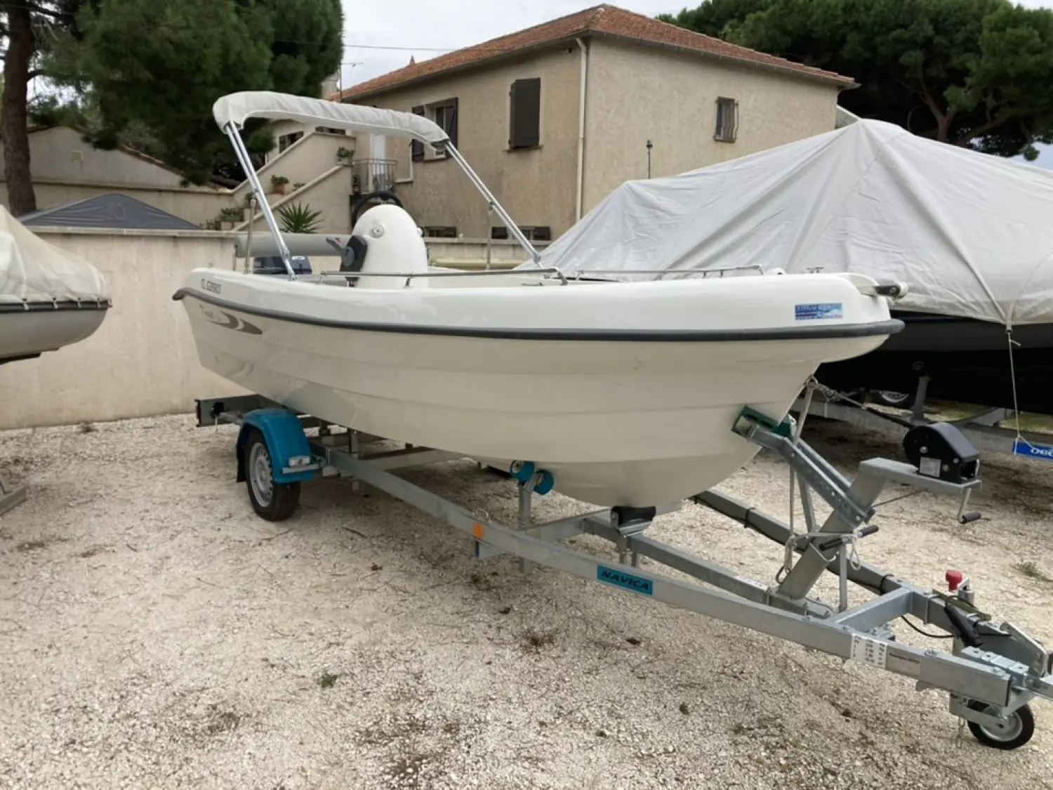 Karel V160 — Bateau à moteur blanc équipé d’un taud, présenté sur une remorque.
