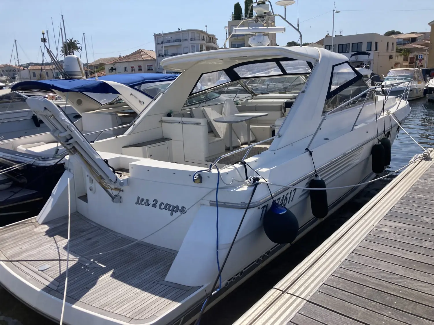 Fairline Targa 42 — Bateau à moteur blanc amarré dans un port, vu de trois quarts arrière.