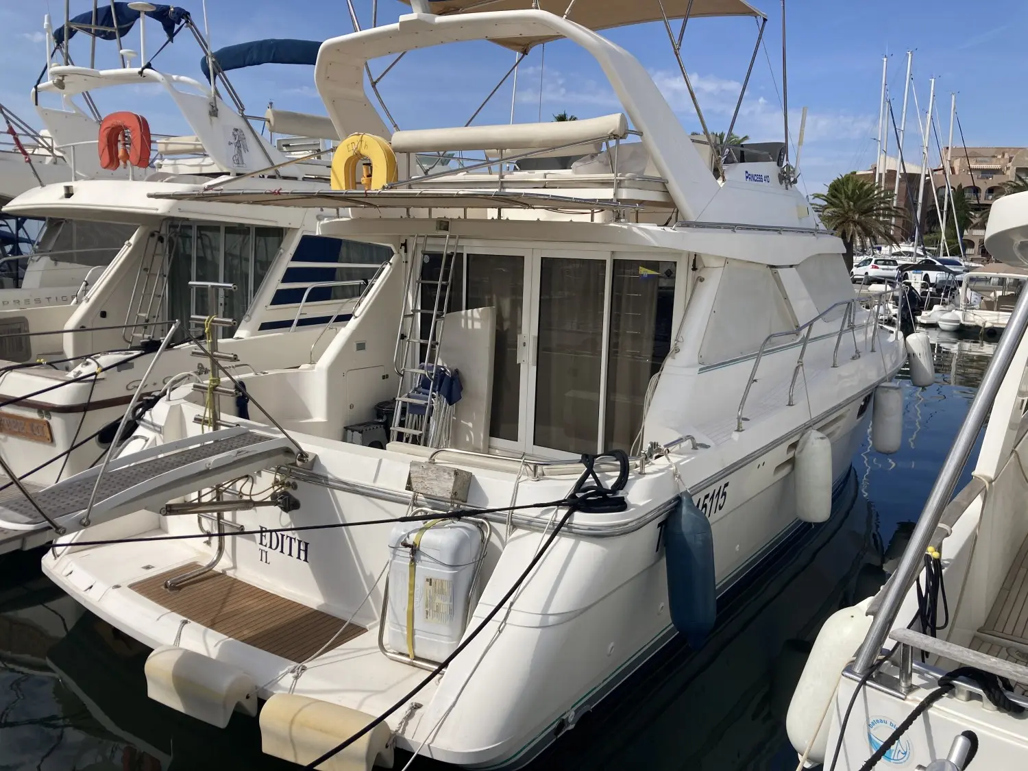 Princess 410 — Vedette blanche amarrée dans une marina, vue arrière trois quarts.