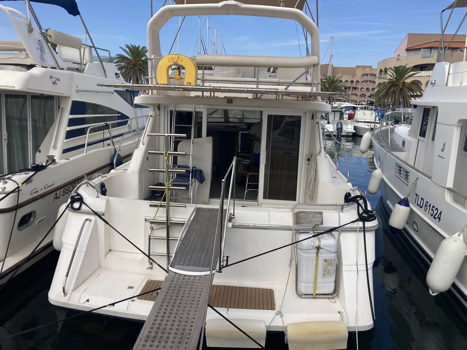Princess 410 — Vue arrière d’un bateau à moteur amarré dans une marina, avec passerelle d’accès.