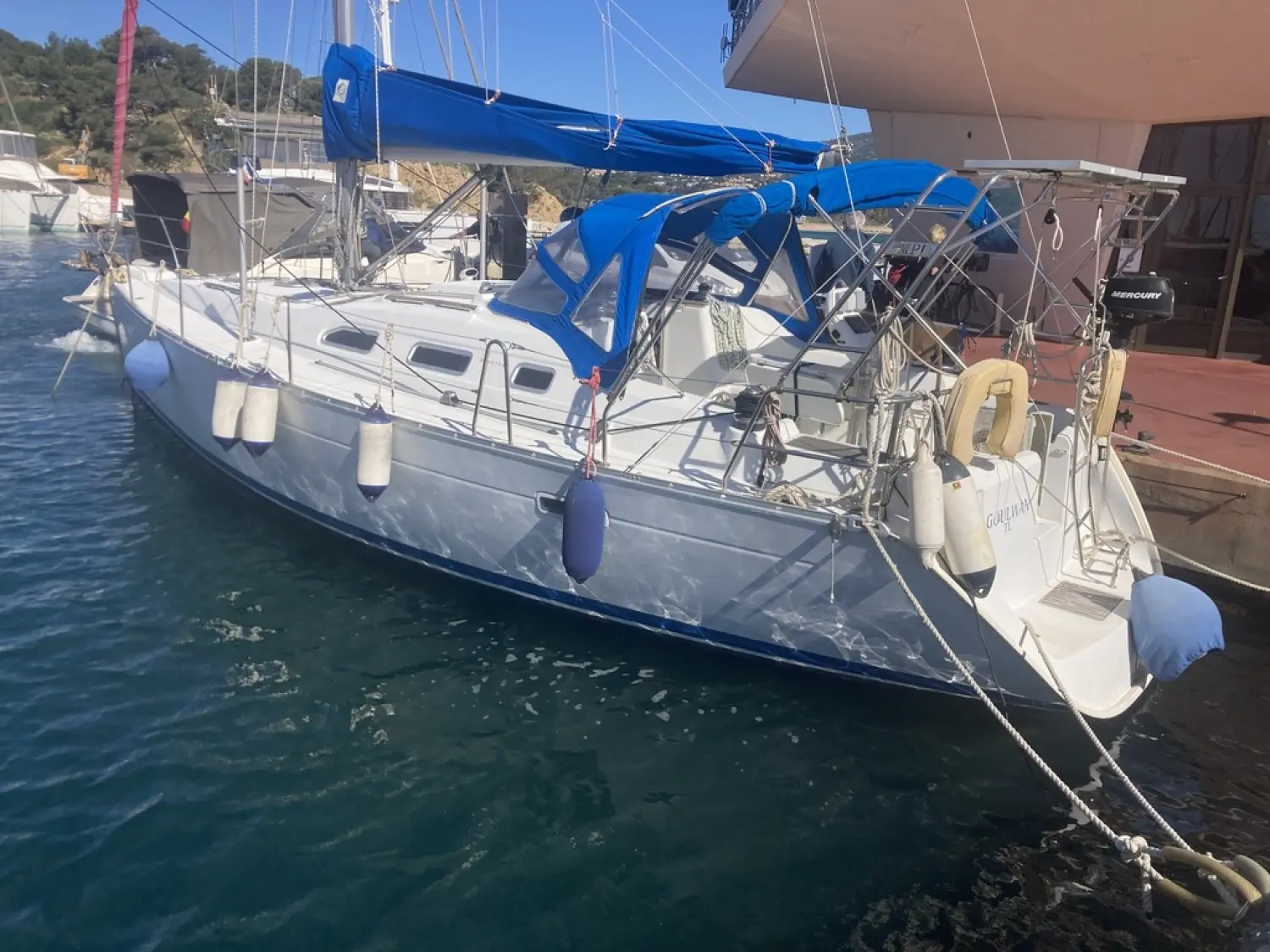 Beneteau Oceanis 393 — Voilier blanc amarré, vu de trois quarts arrière dans une marina.