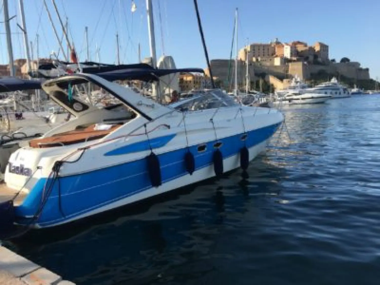 Cranchi Endurance 39 — Bateau à moteur bleu et blanc amarré dans un port, vu de trois quarts arrière.