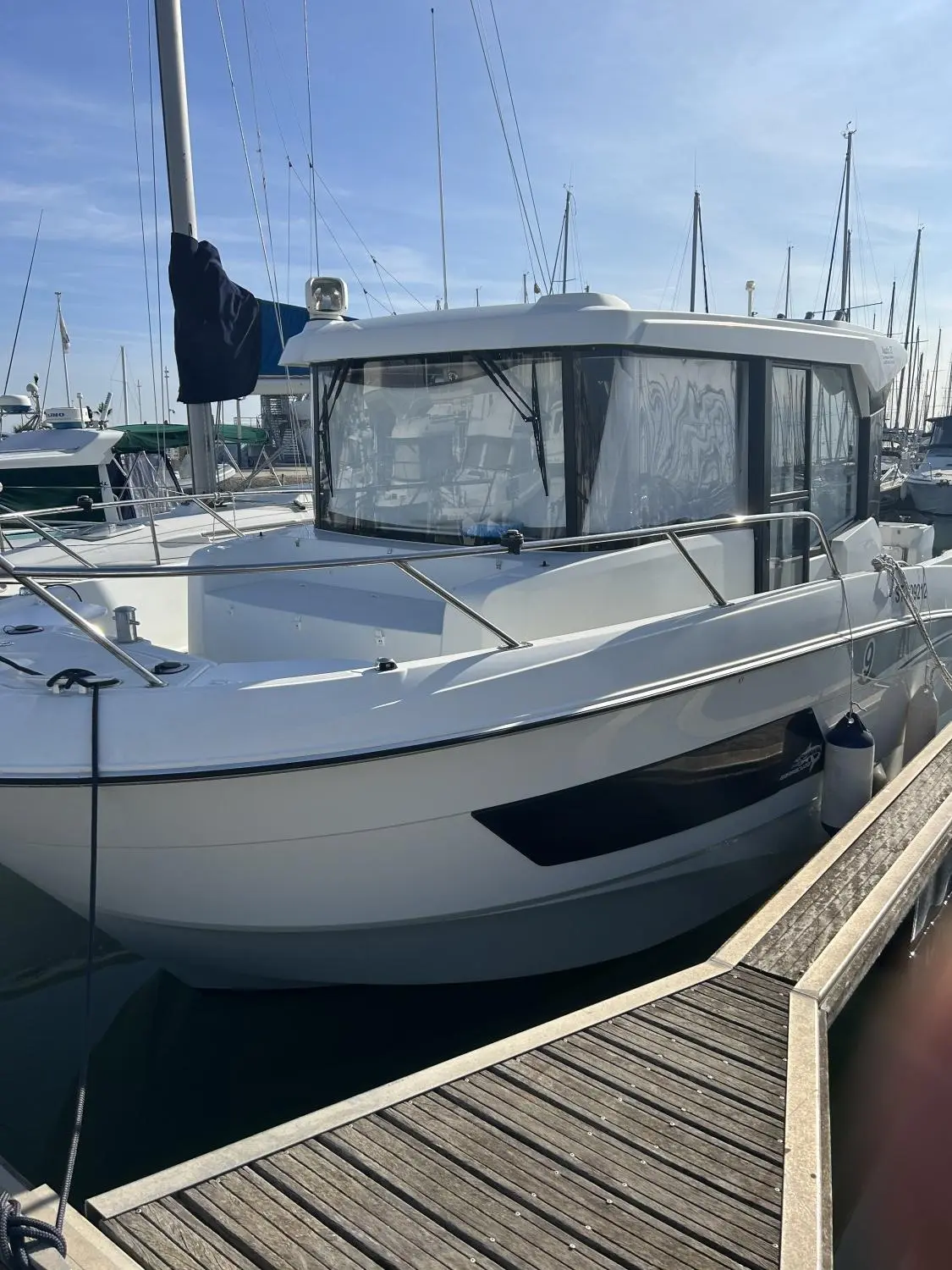 Beneteau Barracuda 9 — Bateau à moteur amarré au ponton, vu de trois quarts par l’avant.
