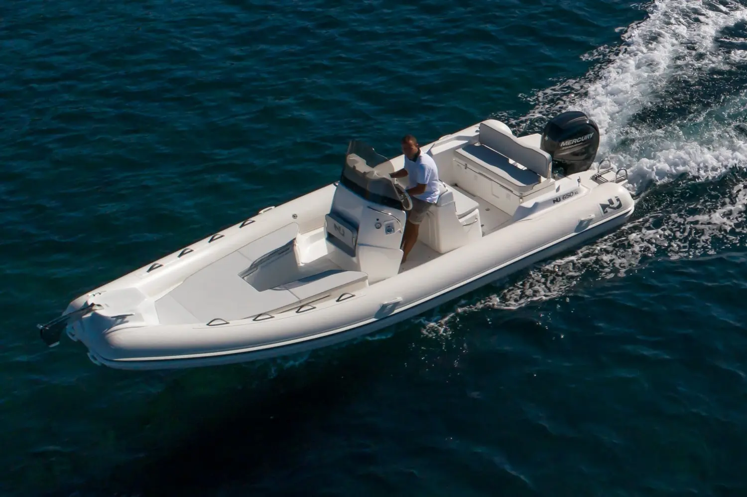 Nuova Jolly NJ 650 — Bateau pneumatique blanc naviguant sur une mer agitée, vu de trois quarts.