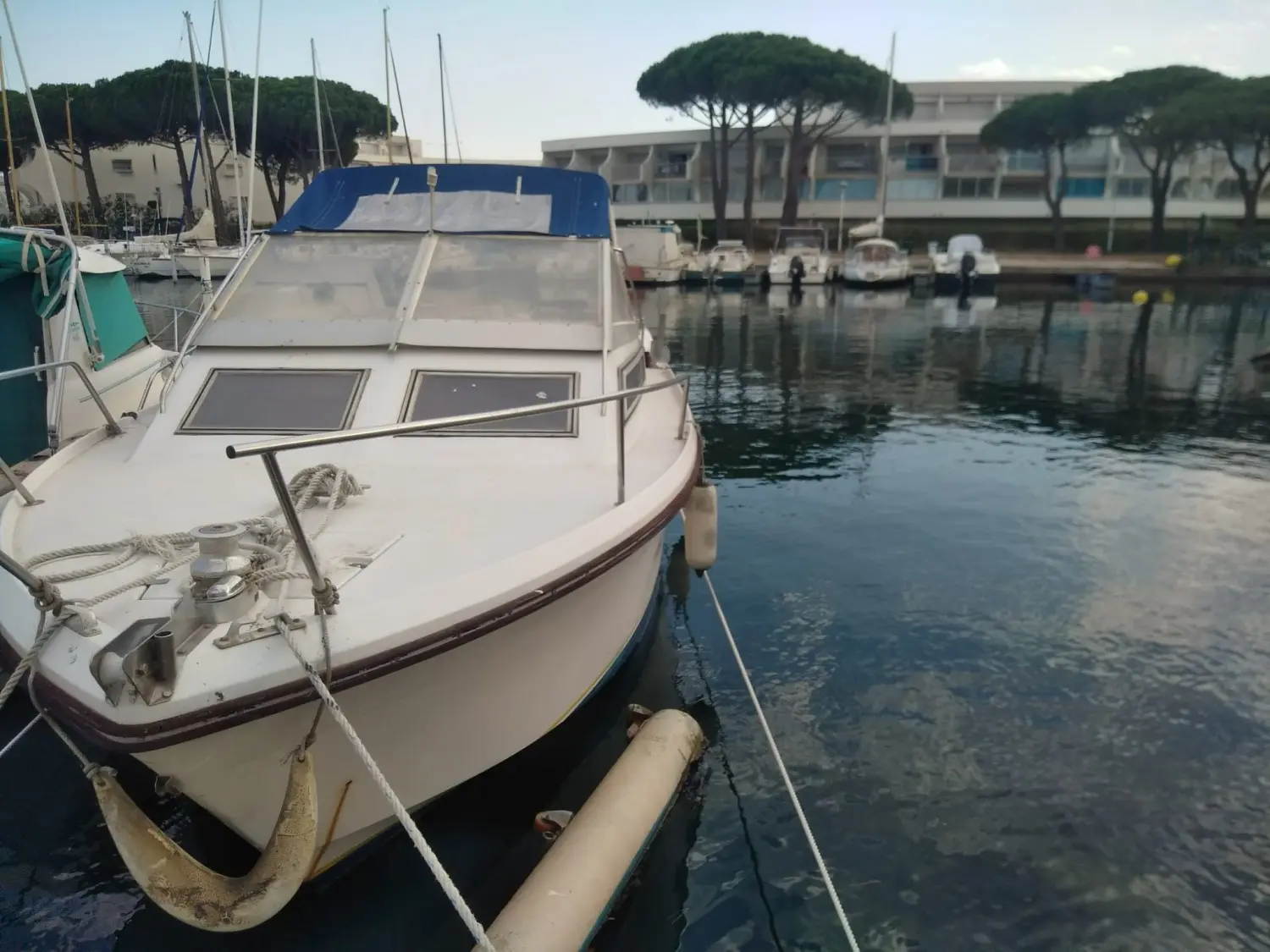 Jeanneau Skanes 750 — Bateau à moteur amarré dans un port, vu de trois quarts avant.
