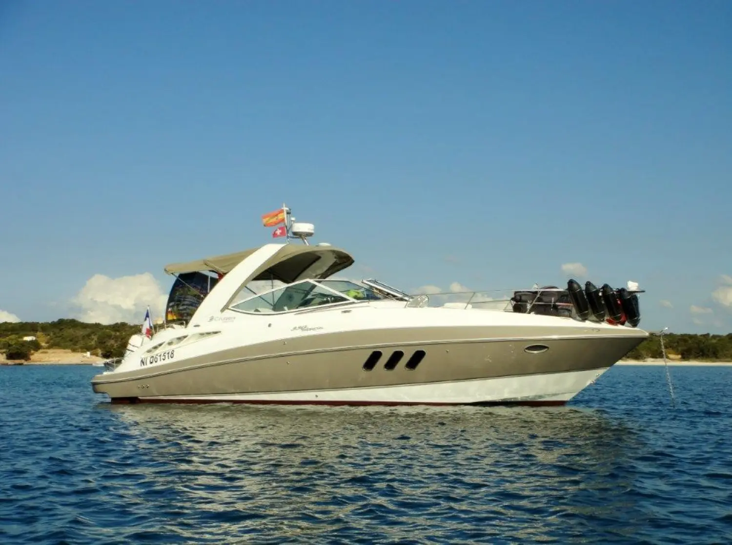 Cruisers Yachts 330 Express — Bateau de plaisance blanc et gris photographié de profil sur l’eau.