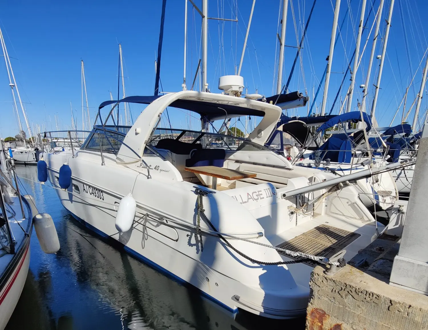 Fiart Mare Fiart 40 Genius — Bateau à moteur blanc vu de trois quarts arrière dans un port de plaisance.