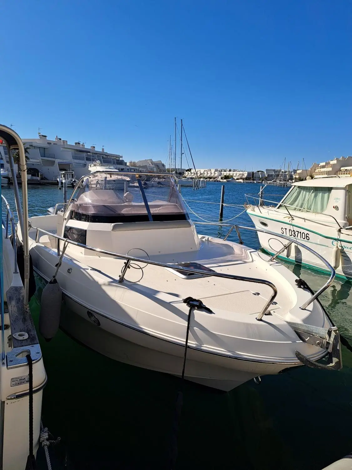 Pacific Craft 815 SC — Bateau à moteur amarré dans un port, vu de trois quarts avant.