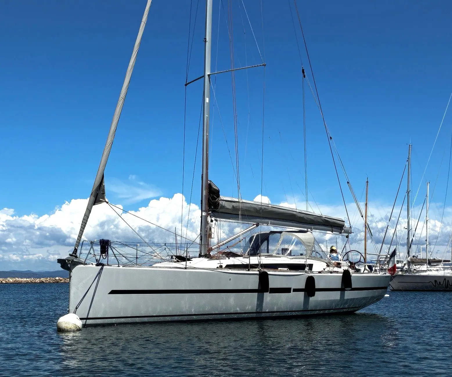 Dufour 36 Performance — Voilier blanc vu de profil dans un port, sous un ciel bleu.