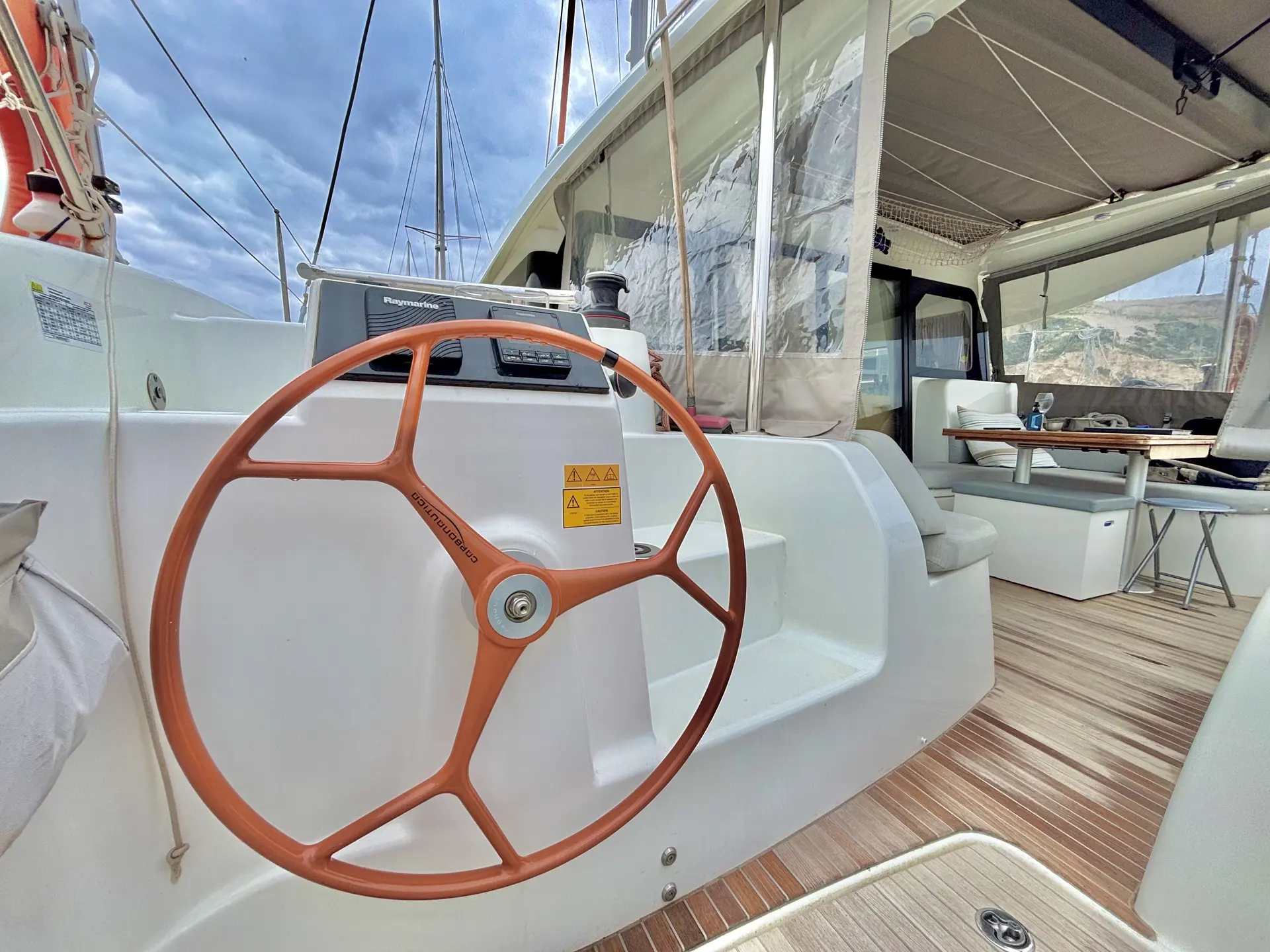 Beneteau Excess 11 — Poste de pilotage et espace de vie extérieur d’un catamaran à quai.
