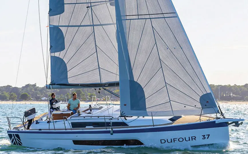 Dufour 37 — Voilier Dufour 37 naviguant au près, avec deux personnes à bord.