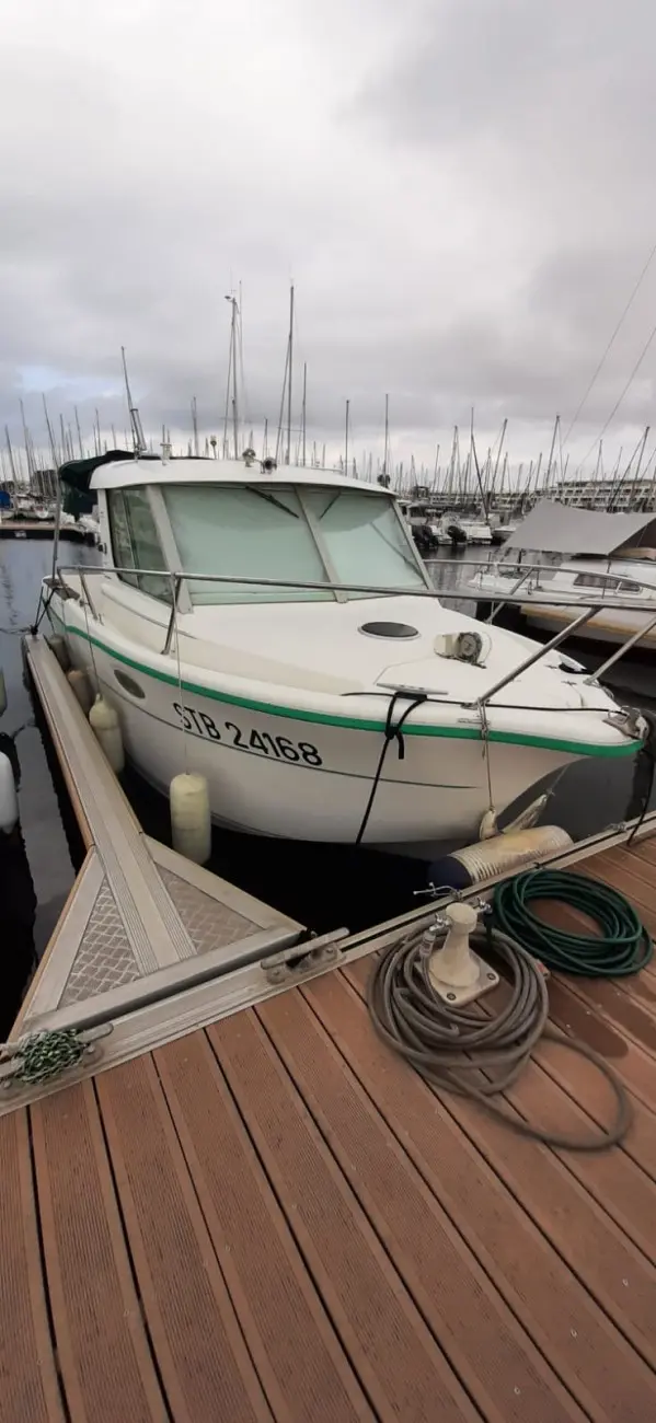 Ocqueteau 715 — Bateau à moteur blanc amarré dans une marina, vu de trois quarts avant.