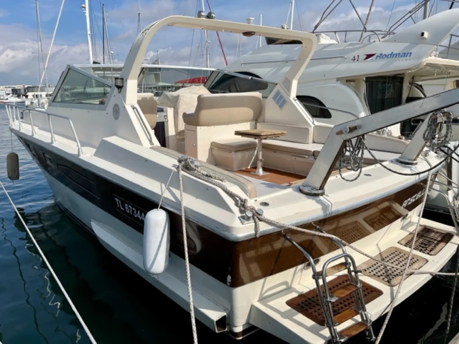 Raffaelli Typhoon Middle Day — Bateau à moteur blanc amarré au port, vu de trois quarts arrière.