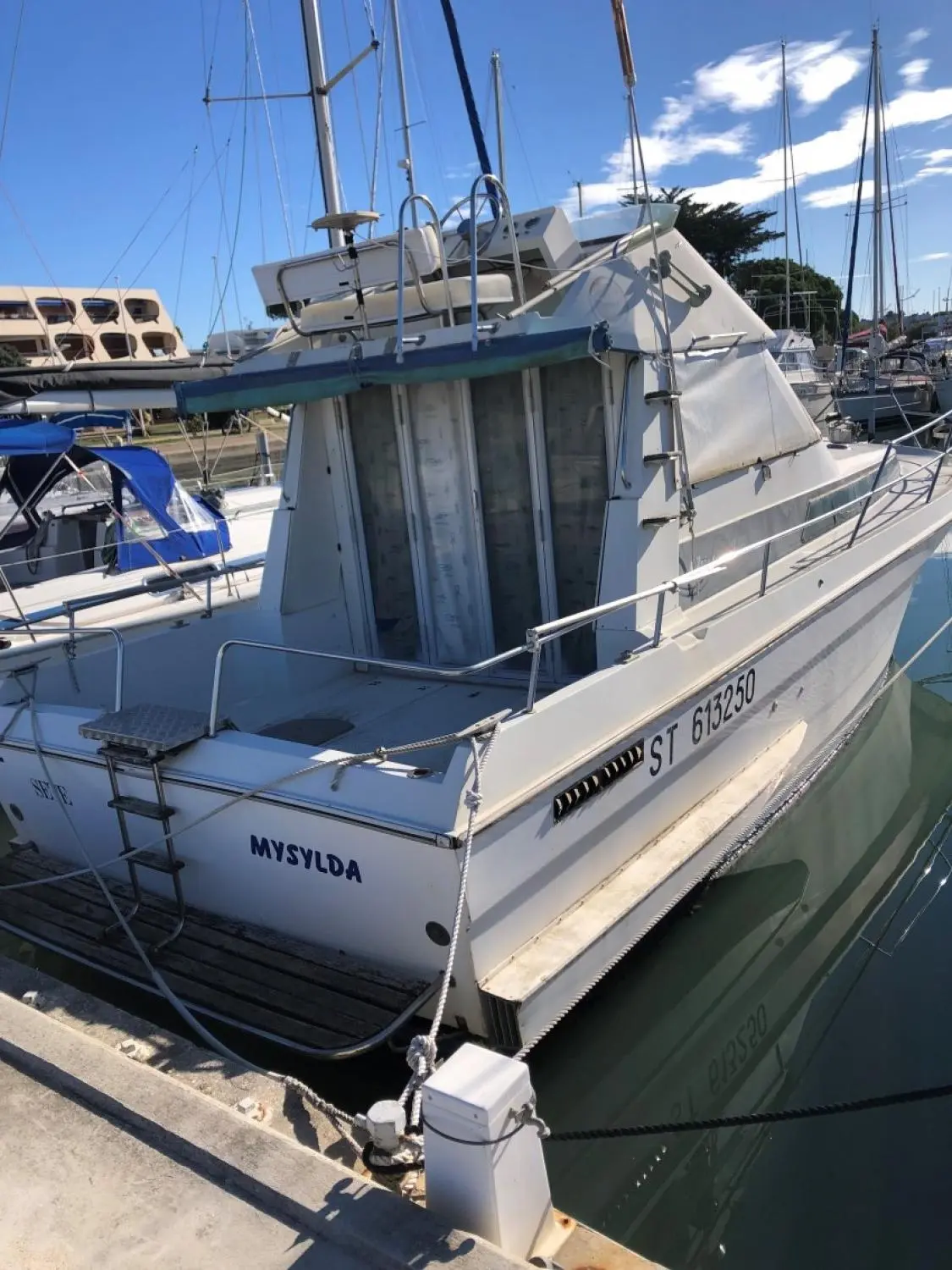 Arcoa 970 FB — Bateau à moteur amarré, vu de trois quarts arrière dans un port.
