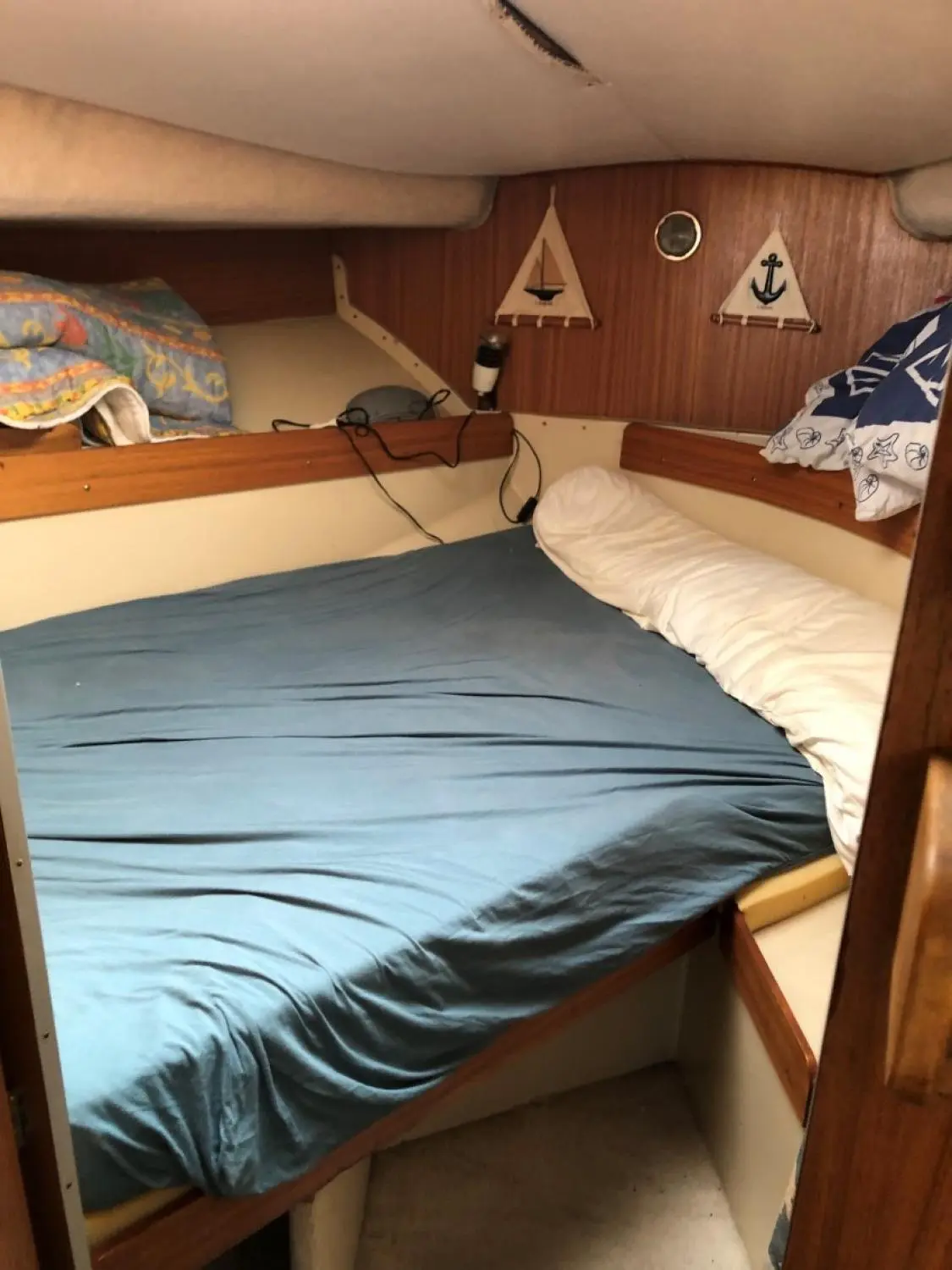Arcoa 970 FB — Couchette intérieure avec literie et boiseries, photographiée depuis l'entrée.