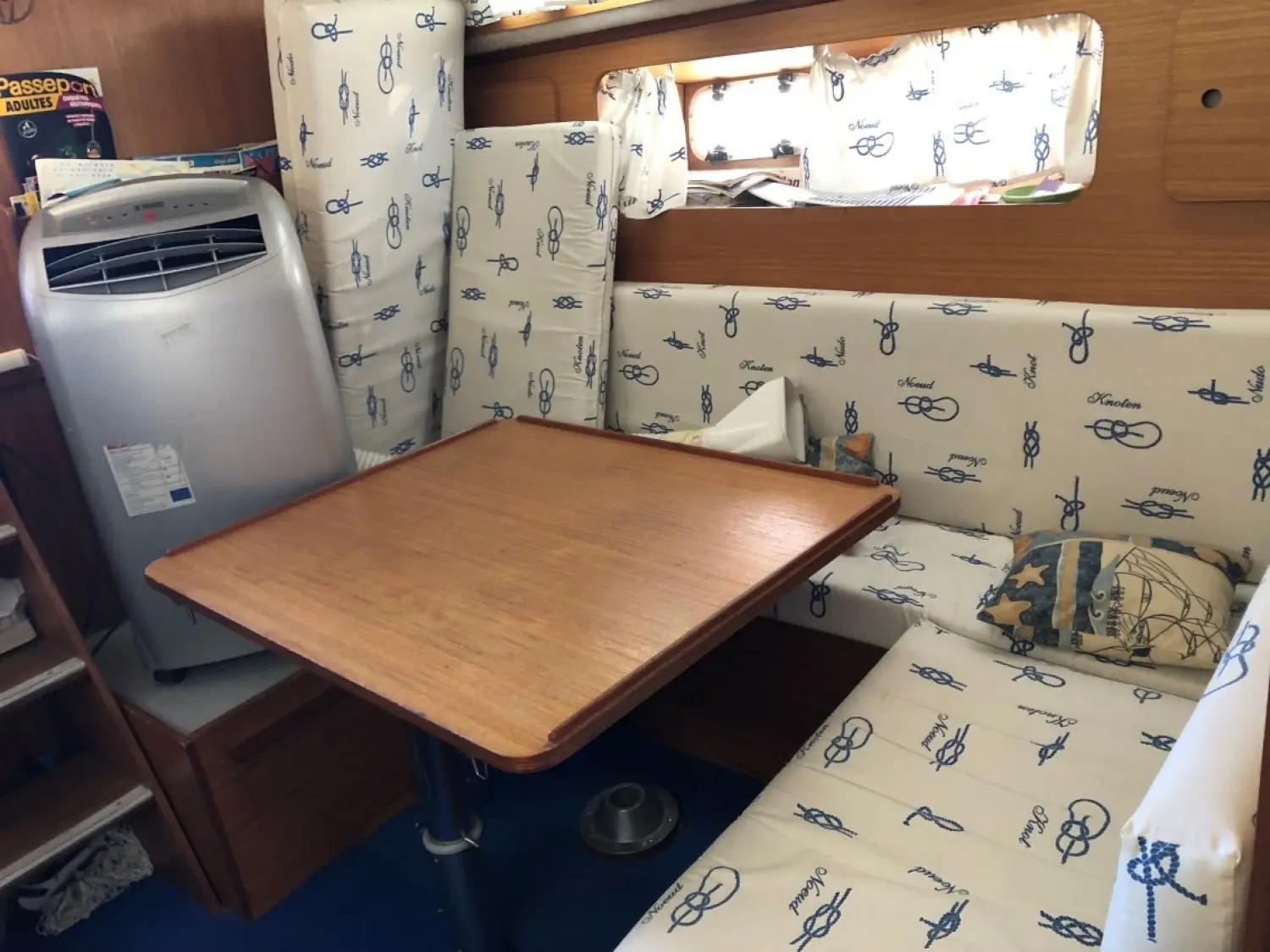 Arcoa 970 FB — Carré intérieur avec table, banquettes et coussins nautiques.