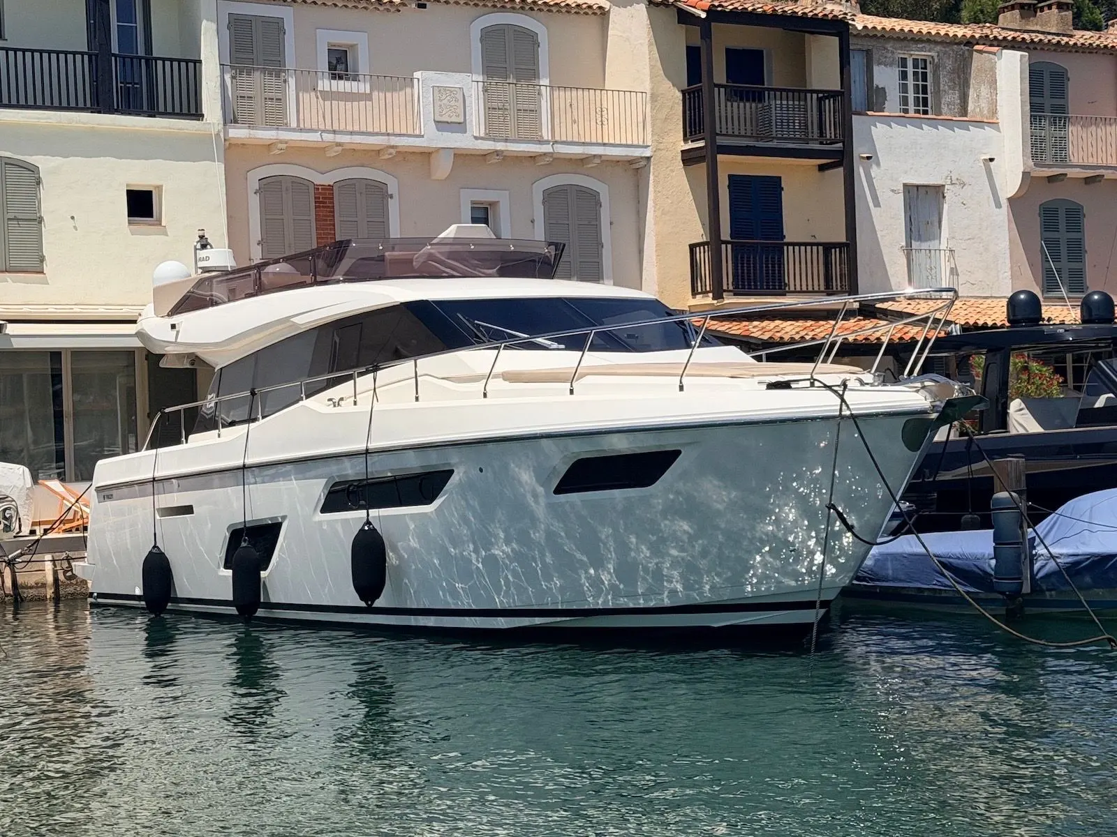 Ferretti 450 — Bateau à moteur blanc amarré, vu de trois quarts bâbord dans un port.