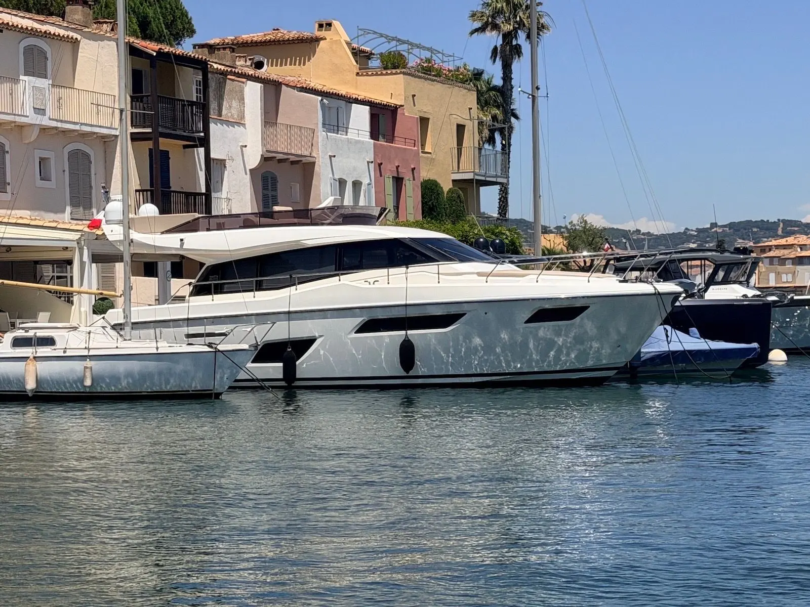Ferretti 450 — Bateau à moteur blanc amarré dans un port, vu de profil.