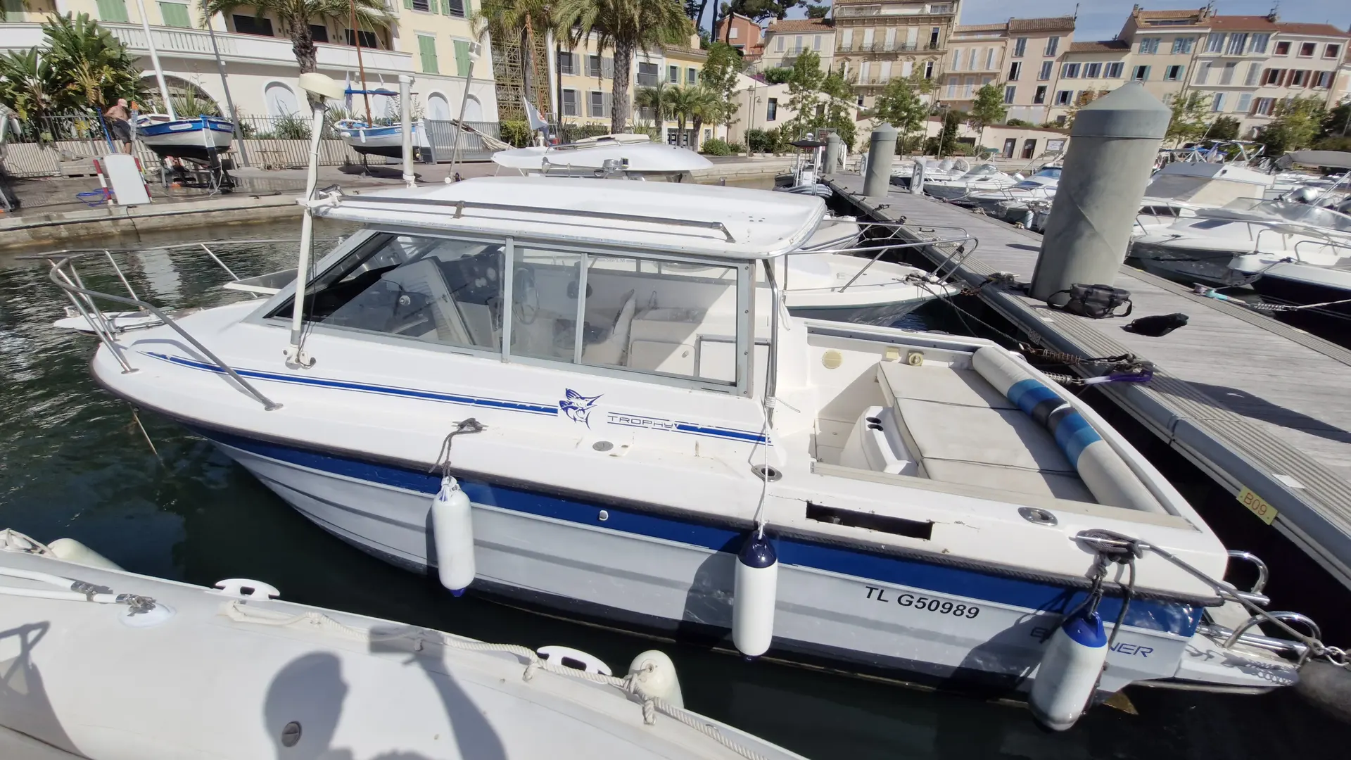 Bayliner Trophy 2159 — Bateau à moteur blanc amarré dans une marina, photographié en vue trois quarts.