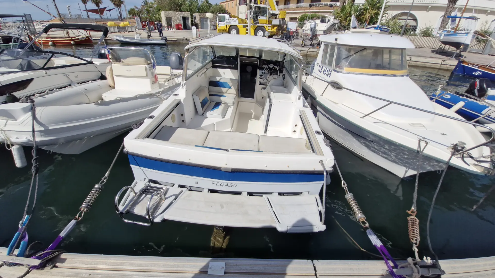 Bayliner Trophy 2159 — Vue arrière d’un bateau blanc amarré dans une marina, entouré d’autres embarcations.