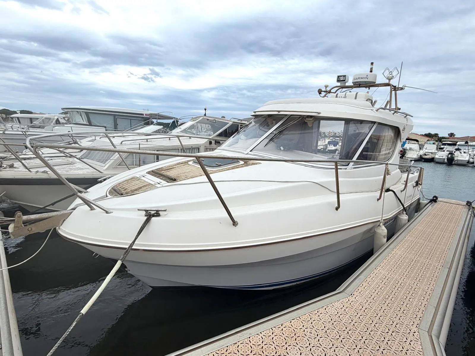 Quicksilver 750 Week-End — Vedette blanche amarrée à un ponton dans un port de plaisance.