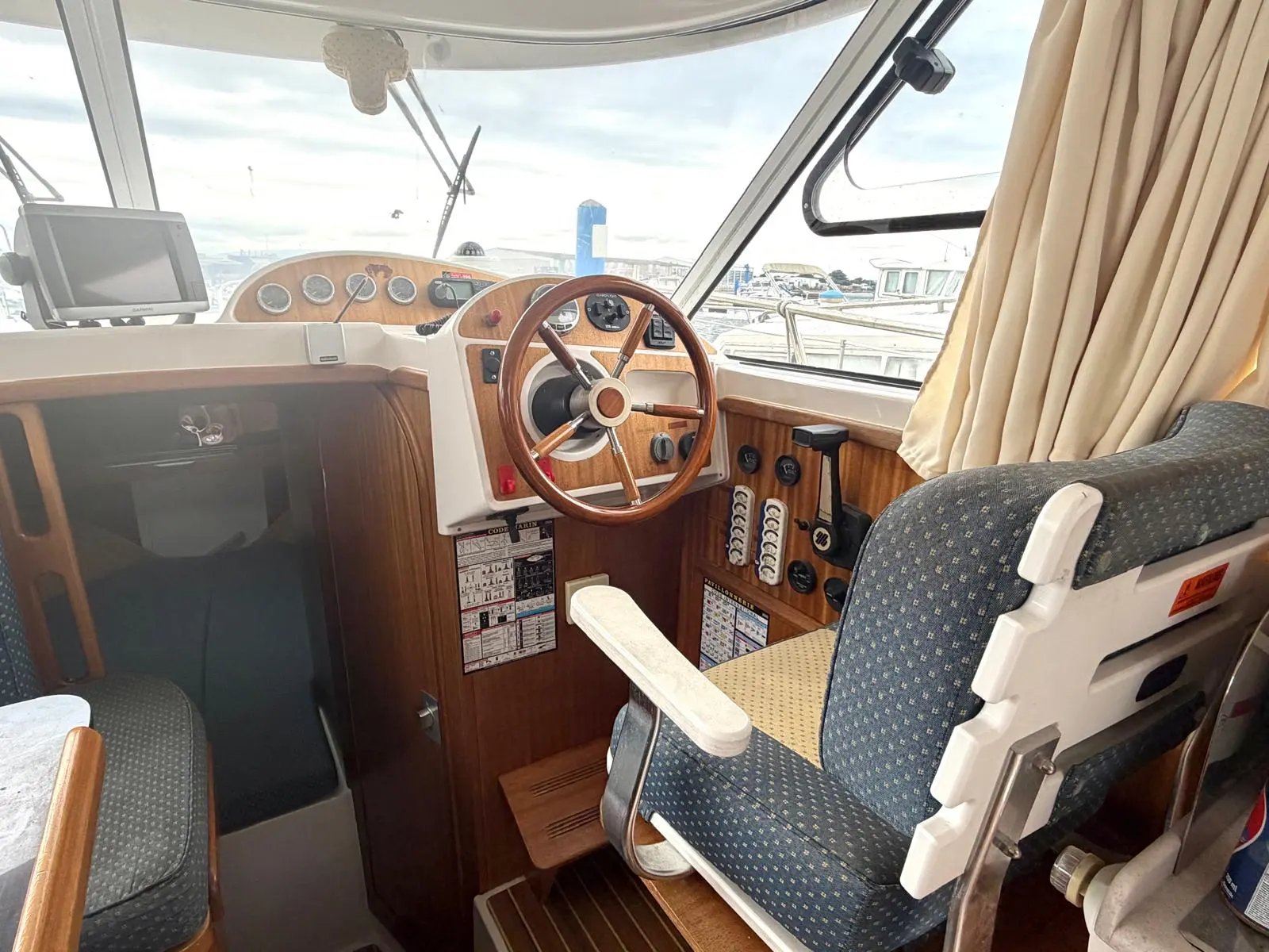 Quicksilver 750 Week-End — Poste de pilotage intérieur avec volant, instruments et sièges.